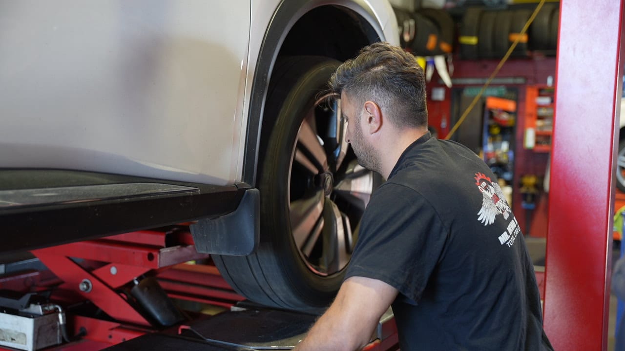 technician performing wheel alignment service at Mr. Memo